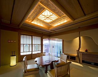 和室の片隅の小庭。網代天井は間接照明で照らされる